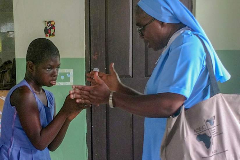 Sr. Francisca Damoah, SIJ, ASEC Regional Director West Africa, plays with a child at St. Elizabeth Day Center for Children & Young Adults with Disabilities, Ghana, during a site visit (June, 2018).