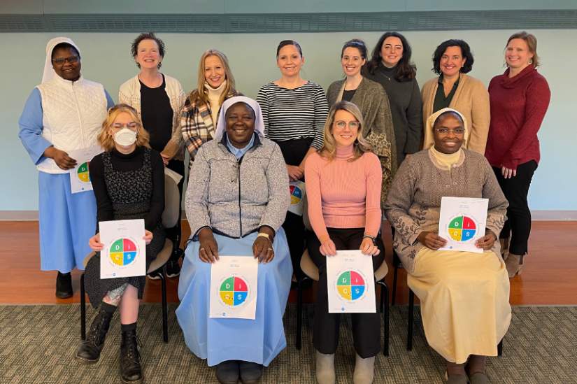 Staff members pose with the DISC assessment chart after the team development conference on February 2, 2023.