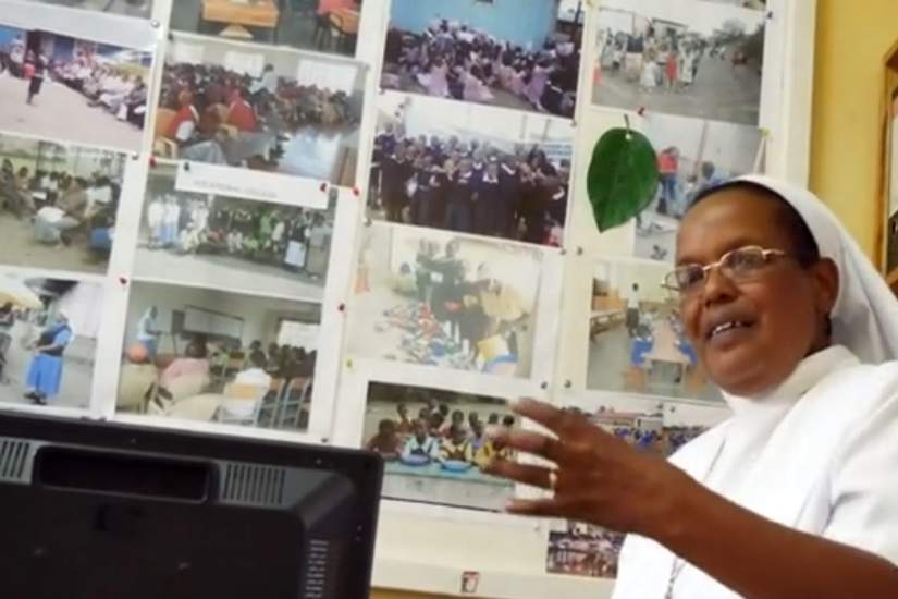 Sr. Mary Wambui speaks to our staff about how the SLDI program has benefited her project. Behind her, a wall of pictures showing all of the children she is serving.