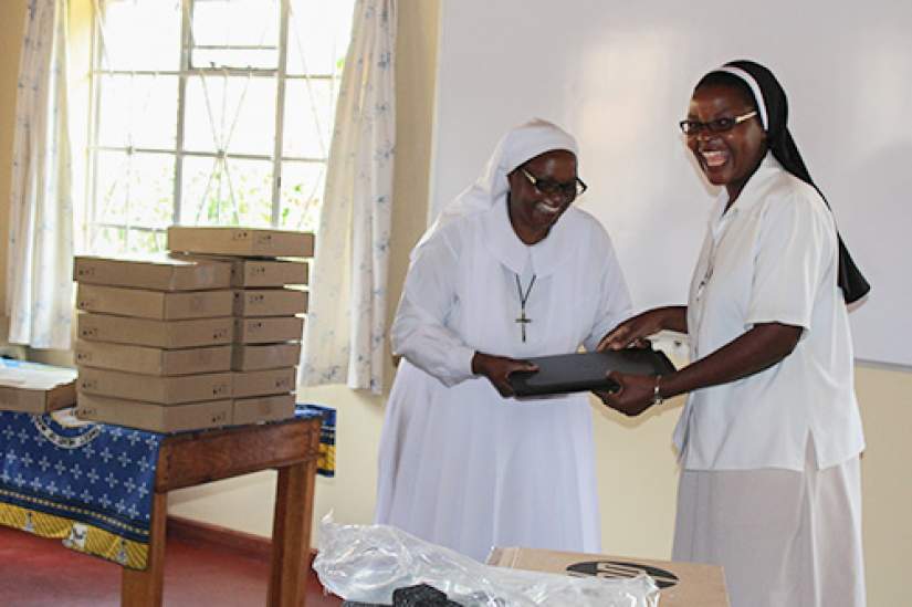 An overjoyed sister in the SLDI administration track, Malawi, receives her new laptop during the opening ceremony of the workshop.