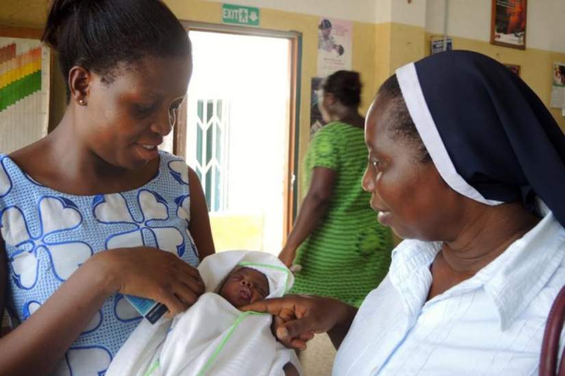 Sr. Mary Frimpong visits with a mother and her premature baby, who was born at 7 months. The mother was at the hospital's Nutrition Rehabilitation Centre, which helps educate families how to cook nutritious and balanced meals. Photo Credit: Global Sisters Report