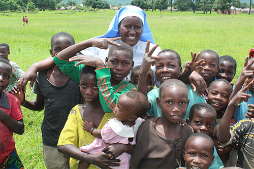 Sr. Maria Telesphora (COLU), ASEC Coordinator – Tanzania poses with children in Sumbawanga.