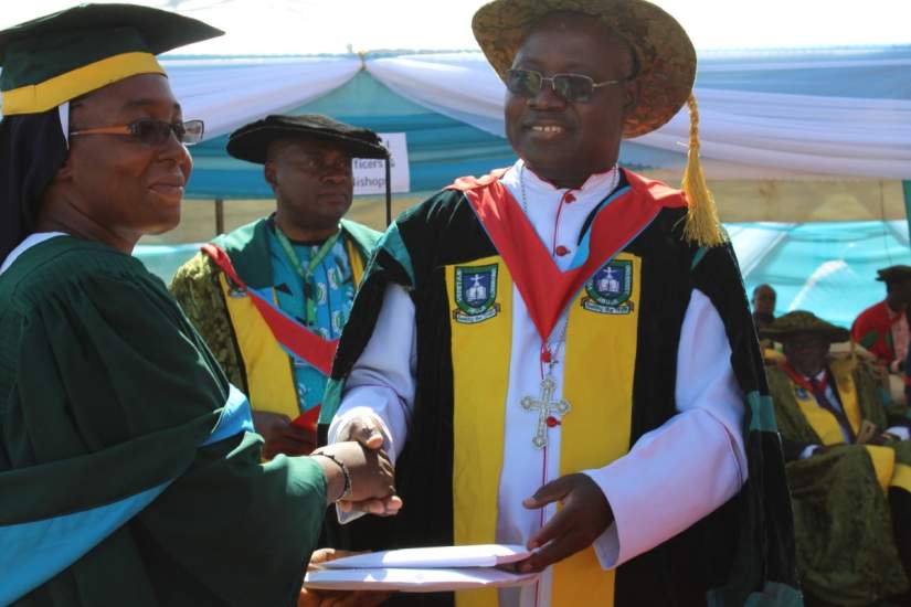 HESA alumna Sr. Lois Moses receiving one of her awards from the archbishop of Jos, Ignatius Ayau Kaigama.