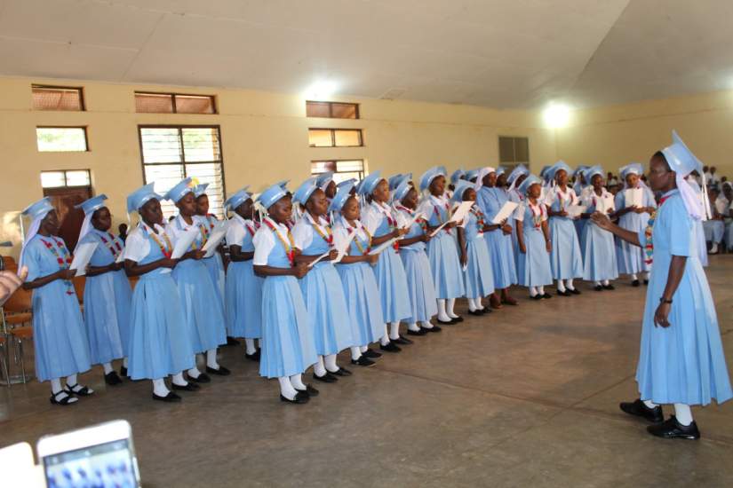 The form six graduate students with their headmistress at the centre Sr. F. Mkwizu at Bigwa Secondary school Tanzania singing during graduation ceremony on April 26, 2017