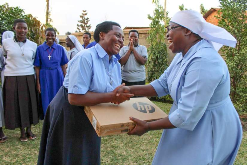 Sr. Irene hands out laptops to participants of ASEC's Sisters Leadership Development Initiative (SLDI) program Finance Workshop.