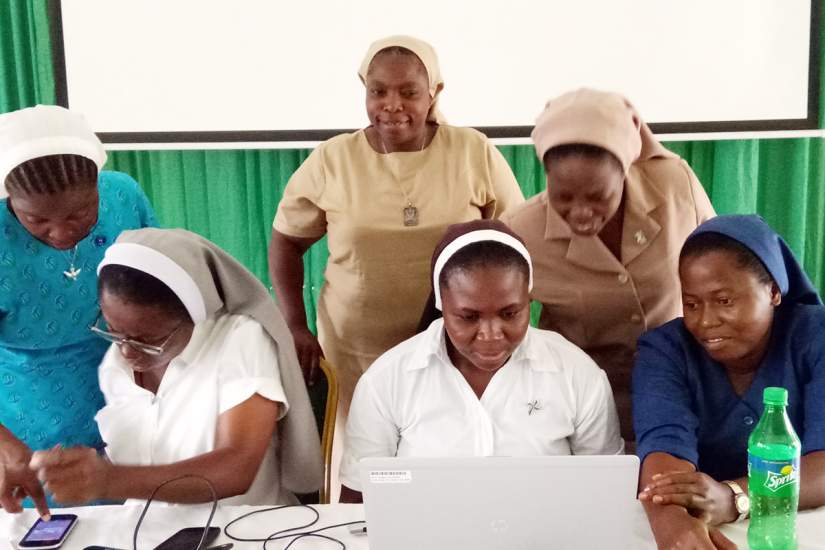 Sisters studying at the Sacred Heart School of Nursing work together with technology as Sr. Clementina Obembe, OSF,
ASEC's Regional Director West Africa, looks on with pride.