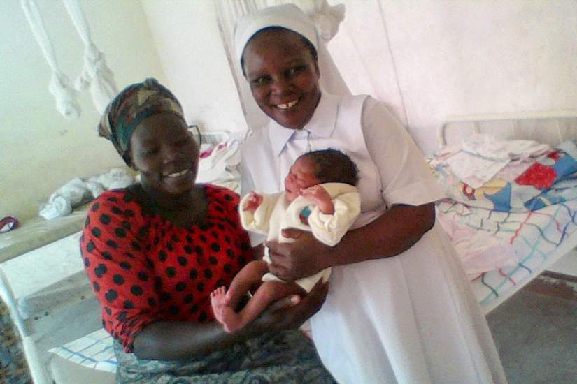 Sr. Olivia with a newborn infant and mother at the health clinic.