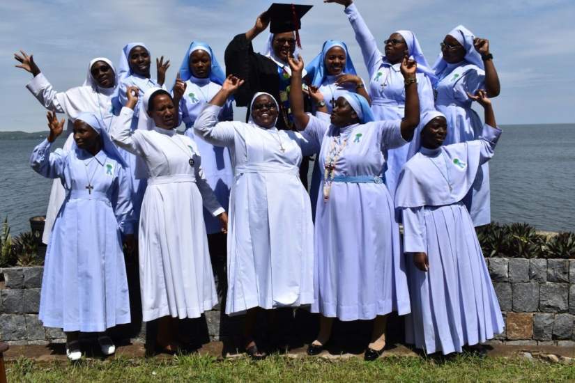 HESA students celebrate their graduation while posing for a photograph.