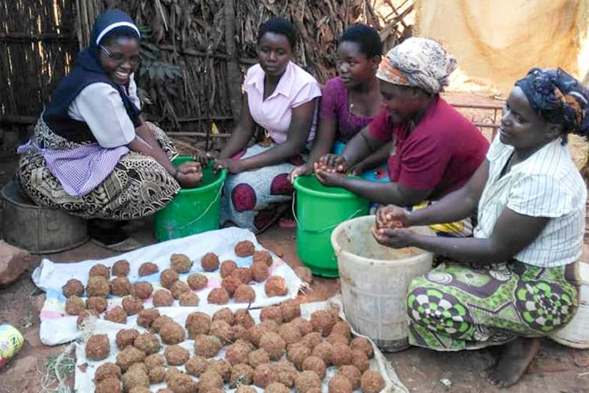 Sr. Jane teaches her sawdust briquette recipe to the women in her community. It has long been a dream of these Malawian women to find an alternative to firewood.