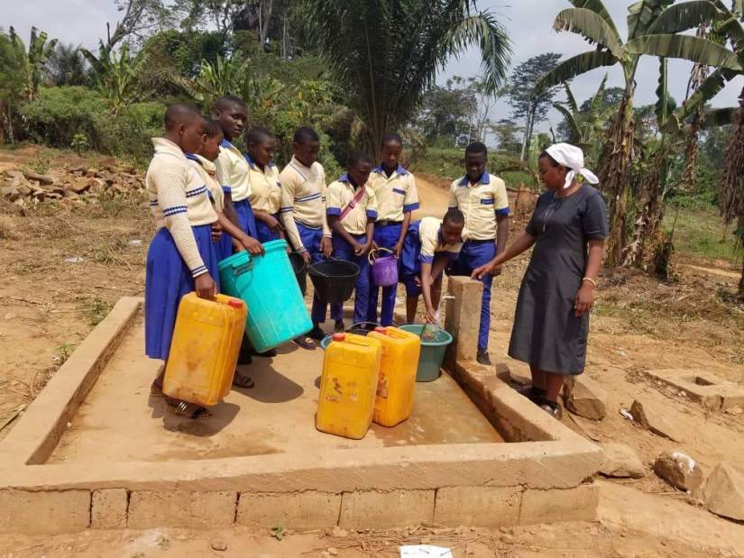 In Cameroon, Catholic sister and ASEC alumna Sr. Yvette Sam, SUSC, helps students fetch water.