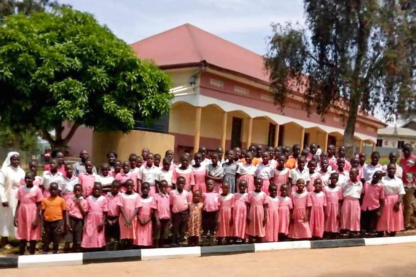 Sr. Betty (far left) poses with students in front of their newly improved school.