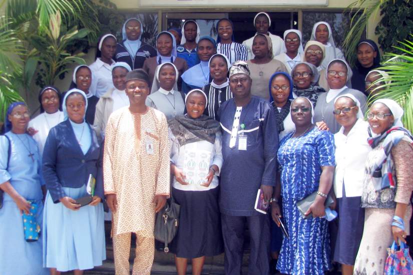 Sisters pose for a group photo in front of the NIPPS Centre of Excellence for Political Parties Studies. With the sisters are Mr. Yakubu Ishaya Labbo, Assistant Chief Executive Officer Protocol (wearing tan) and Mr. Ayuba Yohanna, Executive Officer, Special Duty (wearing blue).