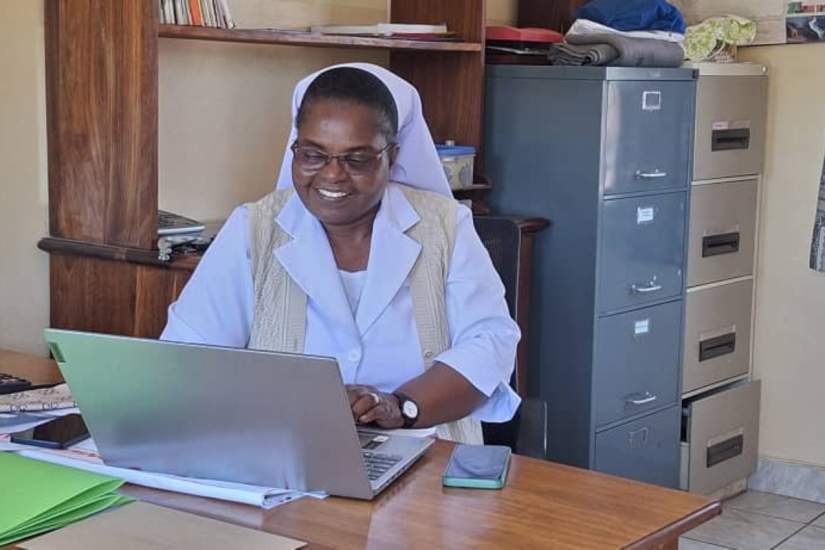 Sr. Chrisencia Twaambo Mkume, RSHS, works at her desk in the diocesan office, where her formation in finance and canon law supports careful stewardship, sound decision-making, and the pursuit of justice within the Church.