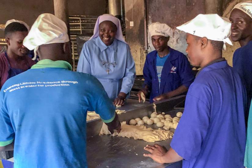 During a site visit in June, 2019, ASEC Executive Director Sr. Draru Mary Cecilia, LSMIG (center), learns the break-making process from bakery staff.