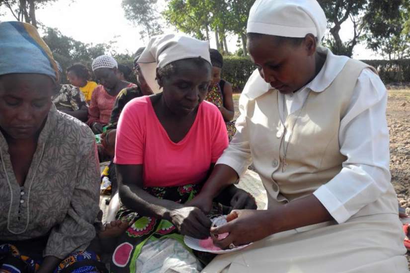 Sr. Josephine, right, helps a woman make a bangle bracelet. Image courtesy of Global Sisters Report (GSR).