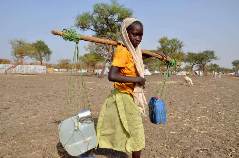 Women and girls spend several hours a day collecting water, often standing in baking heat. They then carry the heavy jerry cans home, either on their heads or tied to the end of poles.