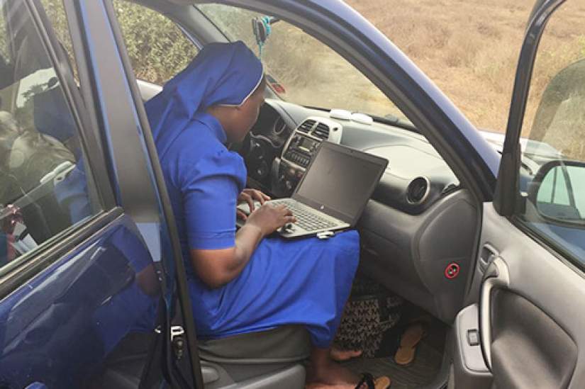 Sr. Clarisse Remjika Jaiwo, ASEC Director, Cameroon, searching for an internet connection on the side of the road.