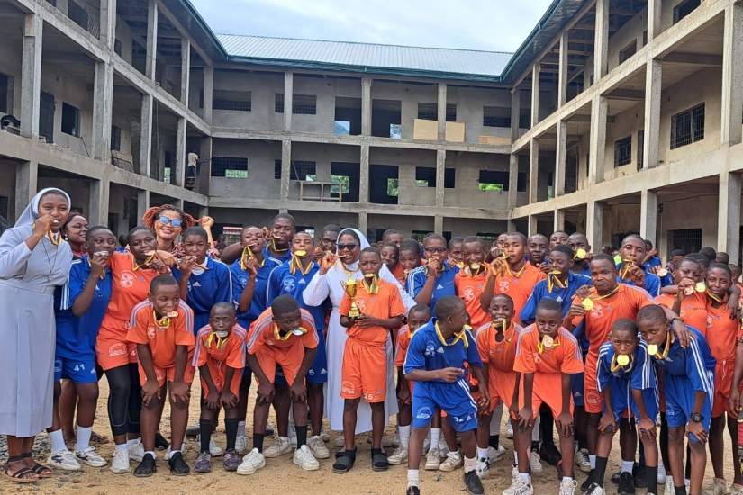 Sr. Vera and students celebrating a football trophy won at the Diocesan level