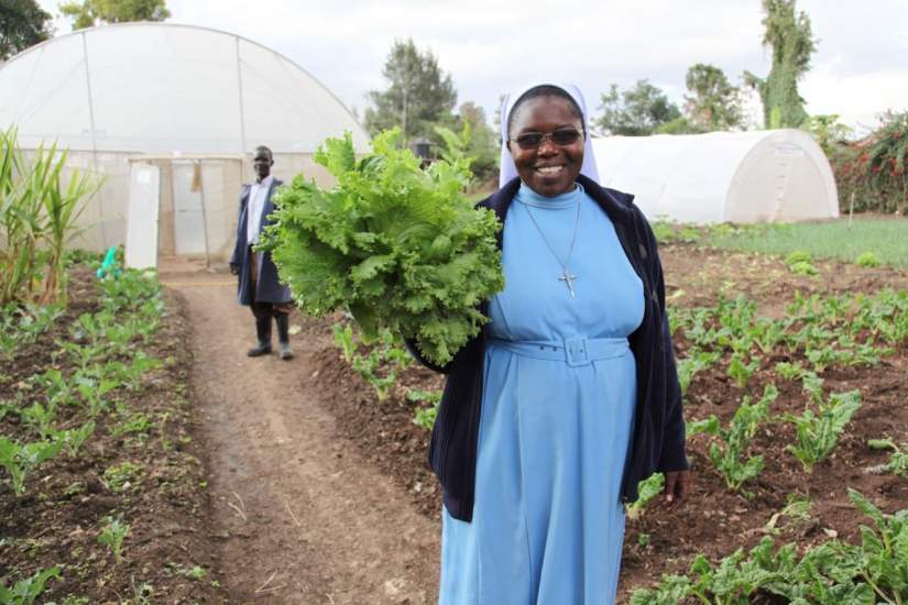 Sr. Catherine Owormungu shows off lettuce from the greenhouse farming project – increased food production to feed children in their schools.