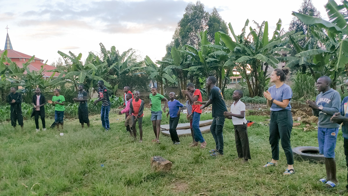 Students are playing a dancing game with street boys from the Ukweli Home of Hope.