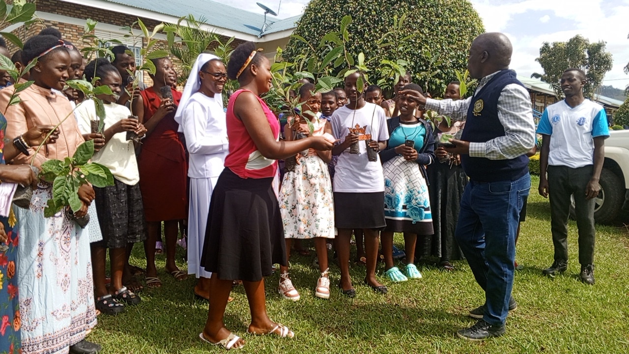 Sr. Gertrude and students receiving fruit trees for planting in order to conserve the environment